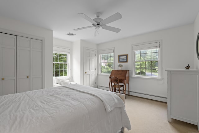 2 Applewood Cmn, East Lyme, CT 06333 - bedroom featuring a baseboard heating unit, multiple windows, light carpet, and two closets