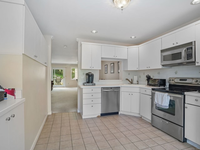 11 Boulevard Dr Unit 10-44, Danbury, CT 06810 - kitchen featuring stainless steel appliances, light countertops, light tile patterned floors, white cabinetry, and recessed lighting