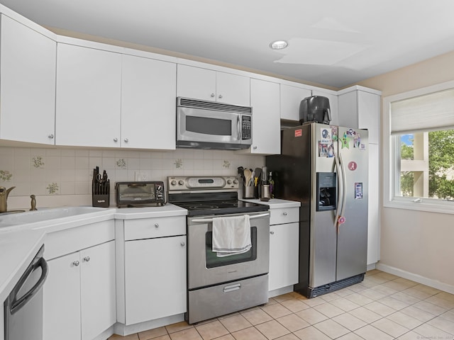 11 Boulevard Dr Unit 10-44, Danbury, CT 06810 - kitchen featuring appliances with stainless steel finishes, light countertops, tasteful backsplash, and white cabinetry
