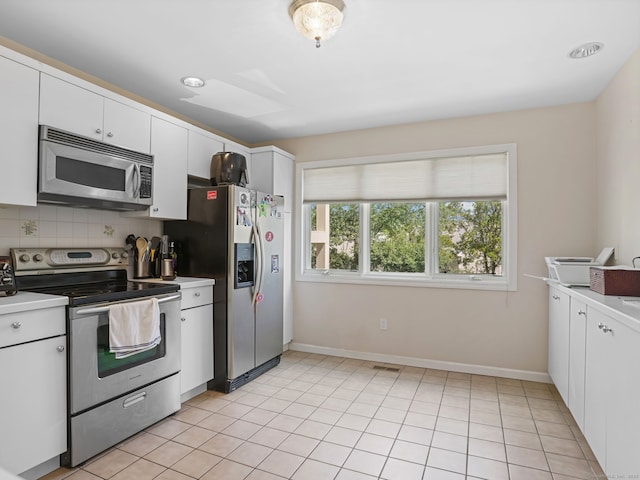 11 Boulevard Dr Unit 10-44, Danbury, CT 06810 - kitchen with appliances with stainless steel finishes, light countertops, white cabinetry, tasteful backsplash, and light tile patterned floors