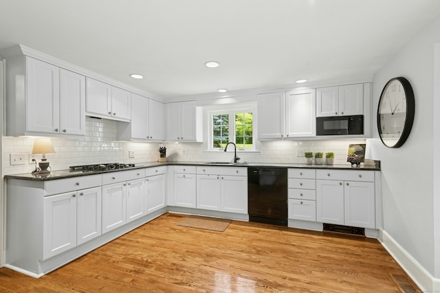 39 Campbell Rd, Fairfield, CT 06824 - kitchen with black appliances, dark countertops, white cabinetry, backsplash, and recessed lighting