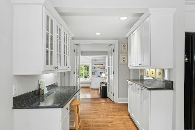 39 Campbell Rd, Fairfield, CT 06824 - kitchen with white cabinetry, light wood finished floors, glass insert cabinets, a breakfast bar, and recessed lighting