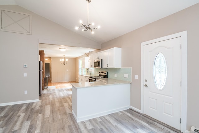 63 Rose Haven Rd, Somers, CT 06071 - kitchen with appliances with stainless steel finishes, a chandelier, vaulted ceiling, light countertops, and light wood finished floors