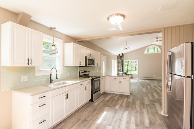 63 Rose Haven Rd, Somers, CT 06071 - kitchen with appliances with stainless steel finishes, a peninsula, vaulted ceiling, light wood-style flooring, and decorative backsplash