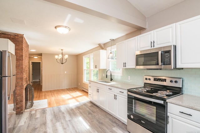 63 Rose Haven Rd, Somers, CT 06071 - kitchen with stainless steel appliances, light wood-style floors, a chandelier, white cabinetry, and a wainscoted wall
