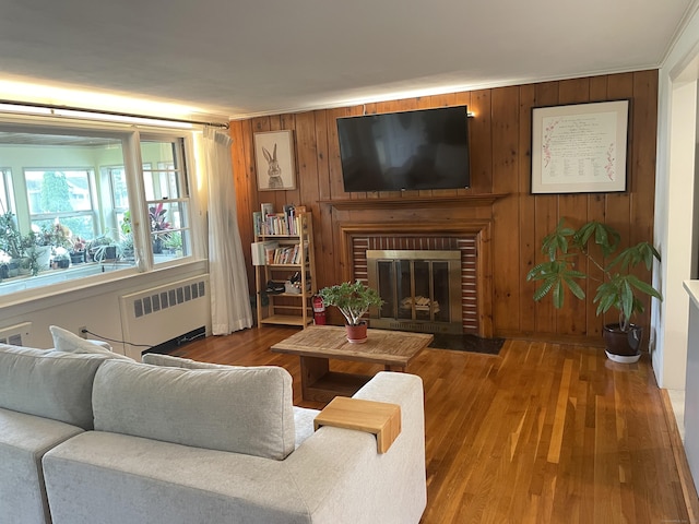 41 Baxter Dr, Norwalk, CT 06854 - living room with radiator heating unit, a brick fireplace, wood finished floors, and wood walls