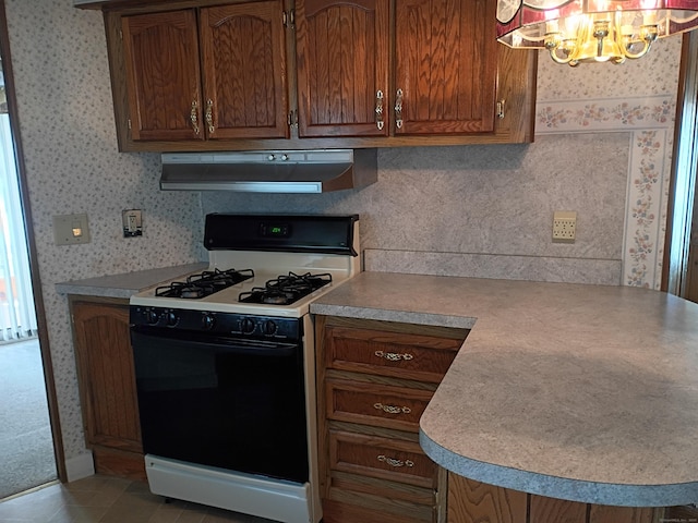65 Woodland Park, Shelton, CT 06484 - kitchen with gas range oven, ventilation hood, a chandelier, wallpapered walls, and brown cabinetry