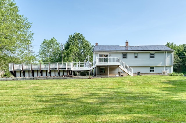 28 Clementel Dr, Durham, CT 06422 - back of house featuring stairway, a deck, a yard, a chimney, and roof mounted solar panels