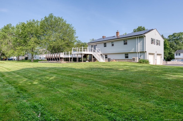 28 Clementel Dr, Durham, CT 06422 - back of property featuring a chimney, stairs, an attached garage, a deck, and a yard