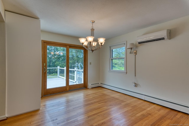 28 Clementel Dr, Durham, CT 06422 - empty room featuring an AC wall unit, a baseboard heating unit, light wood-style flooring, and a chandelier