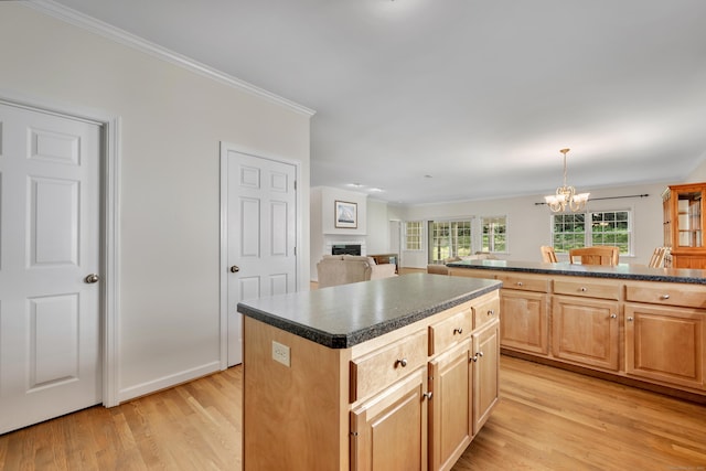 71 Lavender Ln Unit 71, South Windsor, CT 06074 - kitchen featuring a fireplace, dark countertops, light wood finished floors, a center island, and a chandelier