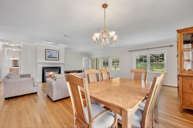71 Lavender Ln Unit 71, South Windsor, CT 06074 - dining room featuring light wood finished floors, ornamental molding, a chandelier, and a glass covered fireplace
