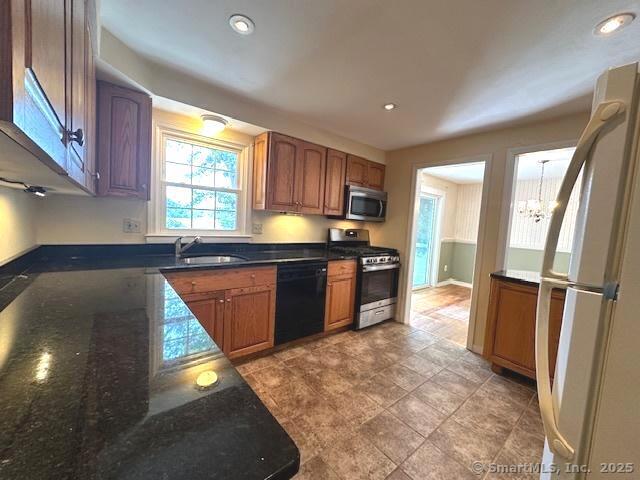 15 Bargate Rd, Clinton, CT 06413 - kitchen featuring stainless steel appliances, a chandelier, dark stone countertops, brown cabinetry, and recessed lighting