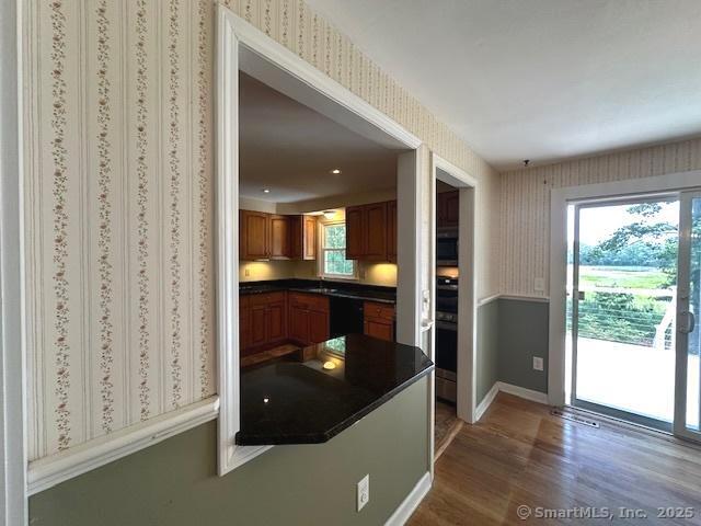 15 Bargate Rd, Clinton, CT 06413 - kitchen featuring wallpapered walls, dark countertops, wood finished floors, black appliances, and plenty of natural light
