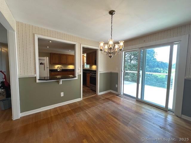 15 Bargate Rd, Clinton, CT 06413 - unfurnished dining area with wallpapered walls, a chandelier, and wood finished floors