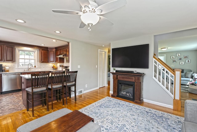 30 Wilcox Rd, Milford, CT 06460 - living area featuring wood finished floors, ceiling fan, stairs, a glass covered fireplace, and recessed lighting