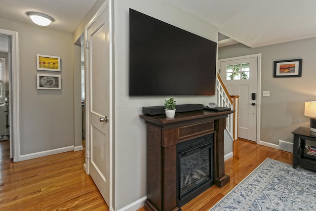 30 Wilcox Rd, Milford, CT 06460 - living area featuring light wood finished floors, a glass covered fireplace, and stairway