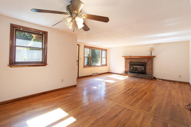 26 Hunt Ln, East Haven, CT 06512 - unfurnished living room featuring a brick fireplace, light wood-style floors, and ceiling fan