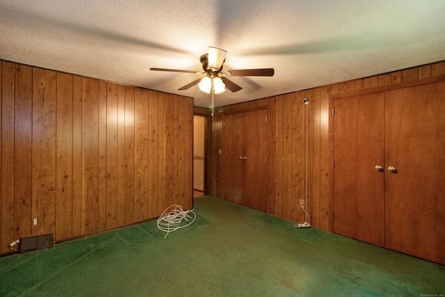 26 Hunt Ln, East Haven, CT 06512 - unfurnished bedroom with carpet, wood walls, a ceiling fan, and a textured ceiling