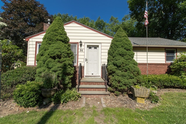 26 Hunt Ln, East Haven, CT 06512 - view of front facade with a chimney and brick siding