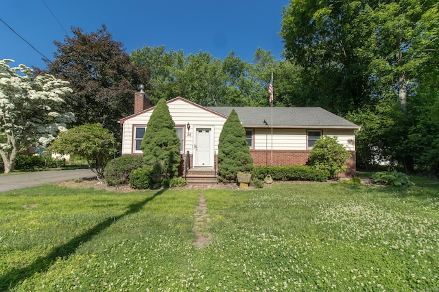 26 Hunt Ln, East Haven, CT 06512 - view of front of home with a chimney, a front yard, and brick siding