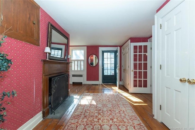 300 Ridgefield Rd, Wilton, CT 06897 - entrance foyer featuring hardwood / wood-style floors, wallpapered walls, radiator, and a fireplace