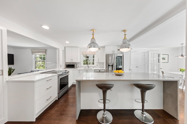 28 Great Hill Rd, Darien, CT 06820 - kitchen with appliances with stainless steel finishes, a kitchen breakfast bar, white cabinetry, a center island, and light countertops