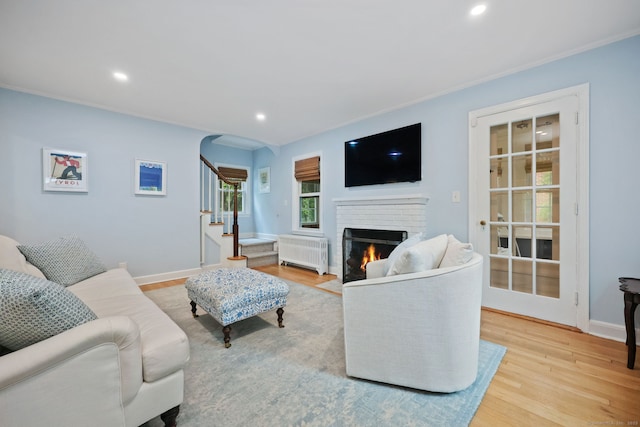 161 Crestwood Rd, Fairfield, CT 06824 - living room featuring radiator, a fireplace, wood finished floors, stairs, and recessed lighting