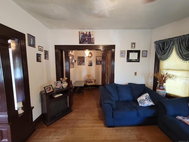 73 Newfield Ave, Bridgeport, CT 06607 - living room with wood finished floors, decorative columns, and a textured ceiling