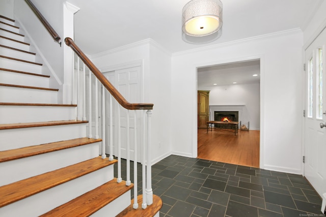 63 Pipers Hill Rd, Wilton, CT 06897 - foyer entrance with stairway, dark tile patterned floors, a lit fireplace, crown molding, and recessed lighting