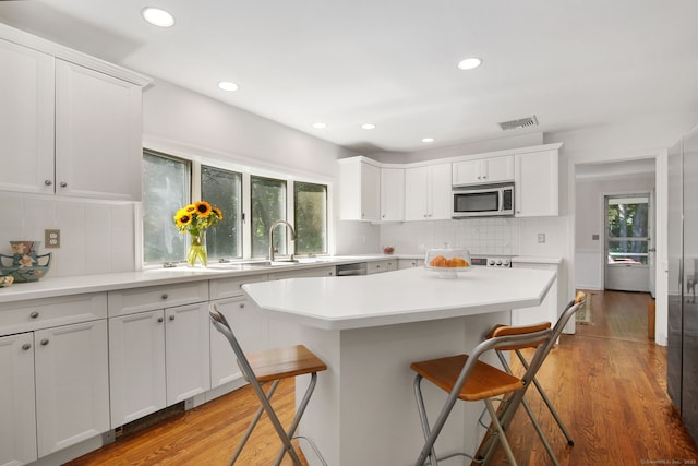 63 Pipers Hill Rd, Wilton, CT 06897 - kitchen featuring stainless steel microwave, a kitchen breakfast bar, plenty of natural light, light countertops, and recessed lighting
