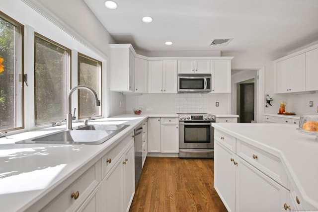 63 Pipers Hill Rd, Wilton, CT 06897 - kitchen with appliances with stainless steel finishes, light countertops, white cabinets, decorative backsplash, and recessed lighting