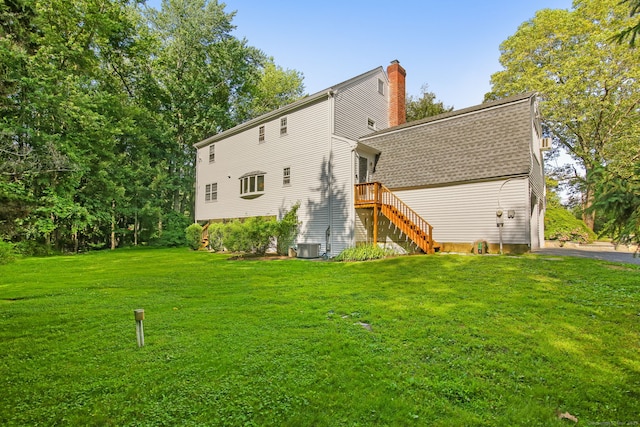 63 Pipers Hill Rd, Wilton, CT 06897 - rear view of property featuring a chimney, a lawn, stairway, and roof with shingles