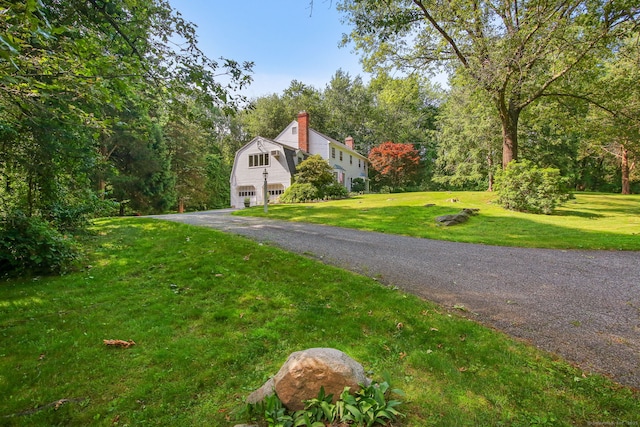 63 Pipers Hill Rd, Wilton, CT 06897 - view of side of home featuring a garage, a gambrel roof, a chimney, asphalt driveway, and a yard