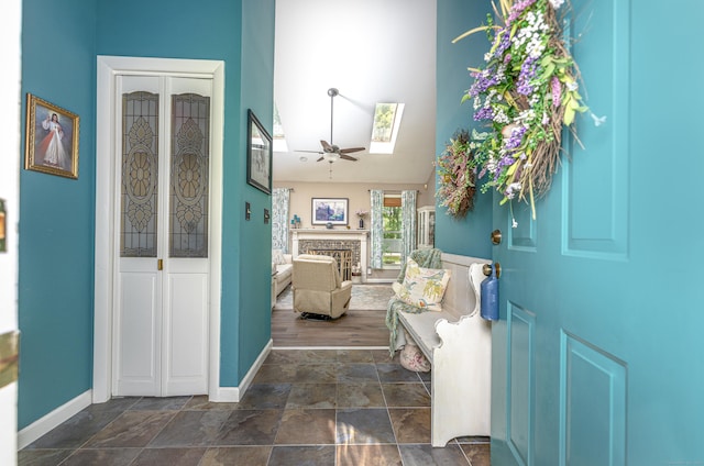 80 Richard Ave, Wolcott, CT 06716 - foyer entrance featuring ceiling fan, a fireplace, a high ceiling, and dark stone finish flooring