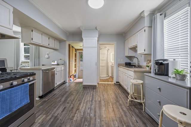 38 Florence St, Manchester, CT 06040 - kitchen with appliances with stainless steel finishes, ornamental molding, white cabinetry, light countertops, and dark wood finished floors