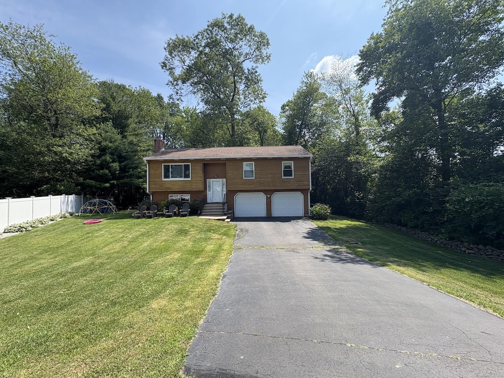 10 Southside Ct, Wallingford, CT 06492 - bi-level home featuring driveway, an attached garage, a chimney, and entry steps