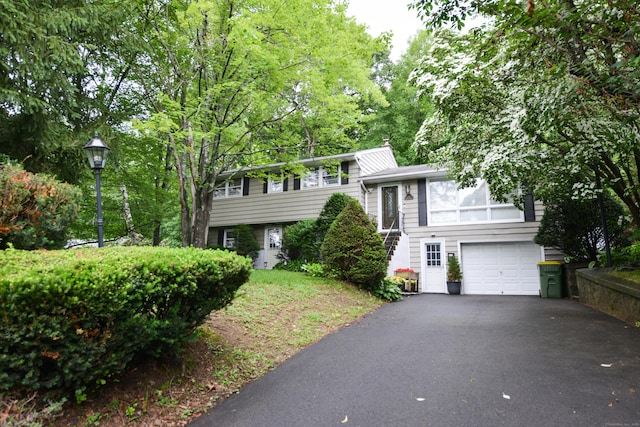 157 Windy Dr, Wolcott, CT 06705 - split level home with driveway, a garage, and a chimney