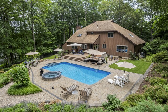 19 Pumpkin Hill Rd, Trumbull, CT 06611 - view of pool with an outdoor hangout area, a wooden deck, a patio, view of wooded area, and a pool with connected hot tub