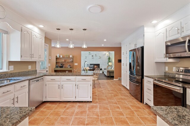 19 Pumpkin Hill Rd, Trumbull, CT 06611 - kitchen with appliances with stainless steel finishes, white cabinets, a large fireplace, pendant lighting, and recessed lighting