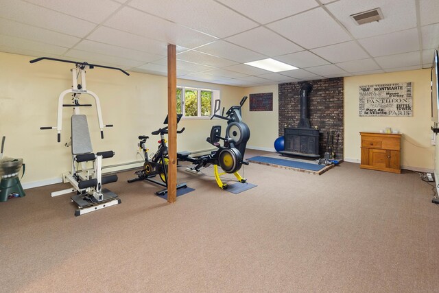 19 Pumpkin Hill Rd, Trumbull, CT 06611 - exercise area featuring a wood stove, a paneled ceiling, and carpet flooring