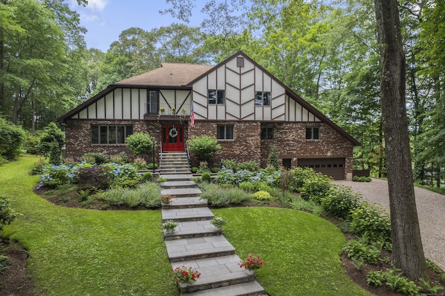 19 Pumpkin Hill Rd, Trumbull, CT 06611 - tudor home featuring a garage, brick siding, driveway, board and batten siding, and a front lawn