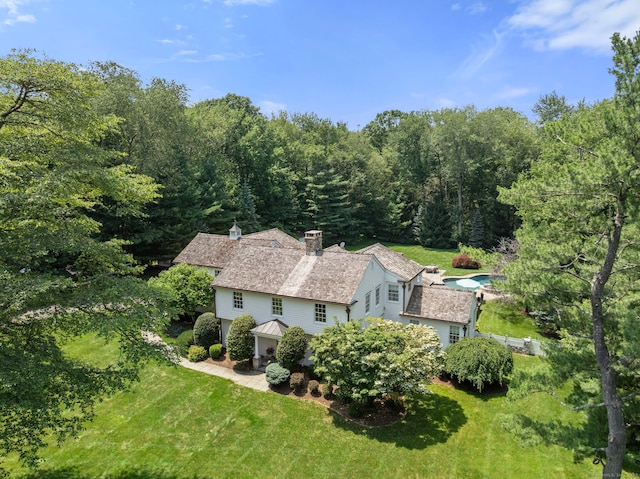 92 Hornbeam Rd, Fairfield, CT 06824 - view of property exterior featuring a chimney, a yard, a patio area, and a forest view