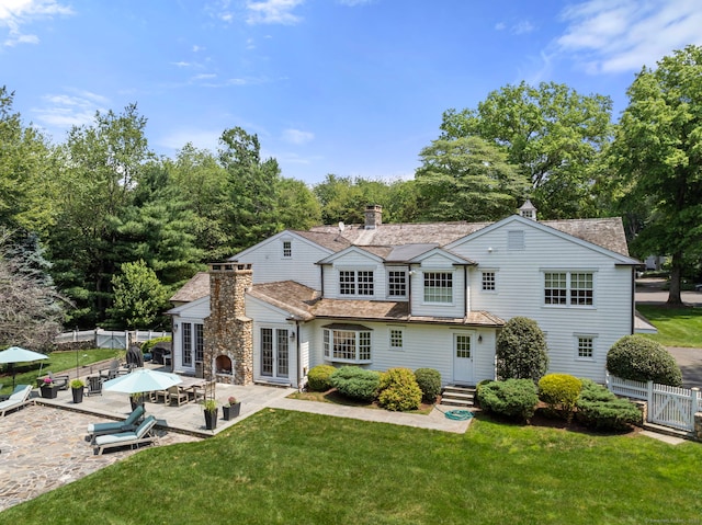 92 Hornbeam Rd, Fairfield, CT 06824 - back of house with a chimney, a patio, entry steps, and view of wooded area