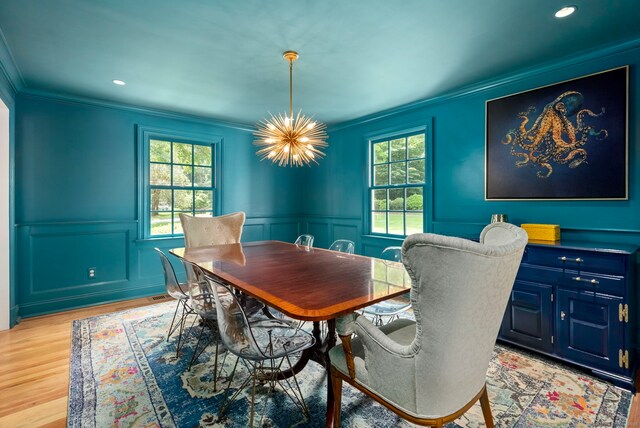 92 Hornbeam Rd, Fairfield, CT 06824 - dining area featuring crown molding, healthy amount of natural light, a wainscoted wall, light wood-style flooring, and a chandelier