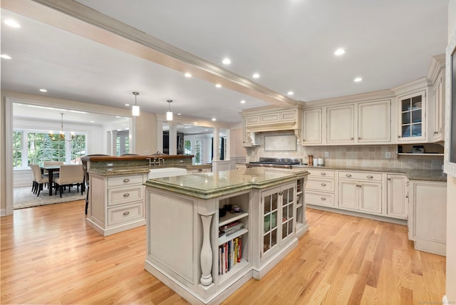 92 Hornbeam Rd, Fairfield, CT 06824 - kitchen featuring a kitchen island, light wood-type flooring, light stone counters, glass insert cabinets, and recessed lighting