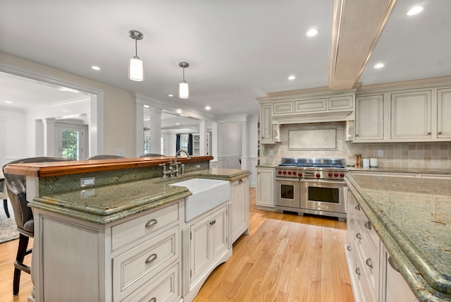 92 Hornbeam Rd, Fairfield, CT 06824 - kitchen featuring double oven range, light wood-style floors, a kitchen breakfast bar, backsplash, and recessed lighting