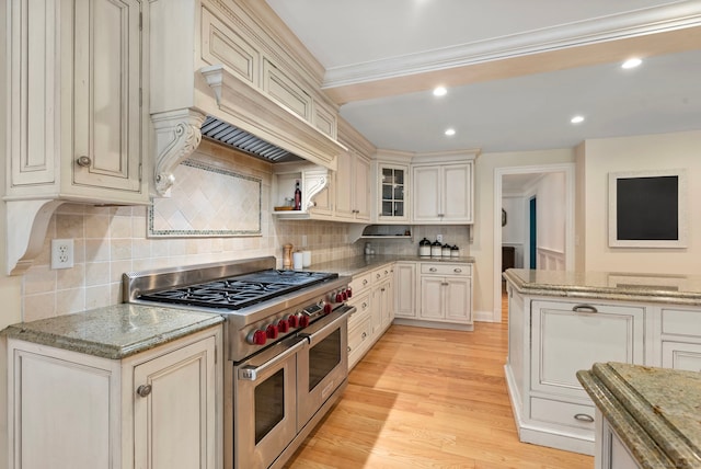 92 Hornbeam Rd, Fairfield, CT 06824 - kitchen with range with two ovens, backsplash, light stone counters, glass insert cabinets, and crown molding