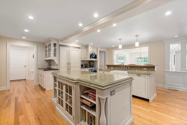 92 Hornbeam Rd, Fairfield, CT 06824 - kitchen featuring a large island with sink, light wood-style floors, glass insert cabinets, recessed lighting, and pendant lighting