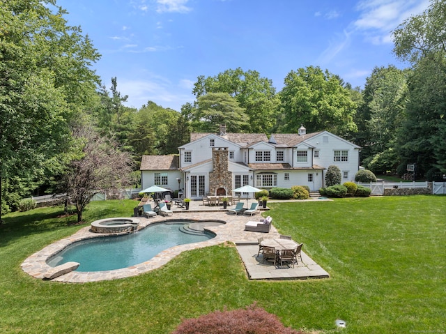 92 Hornbeam Rd, Fairfield, CT 06824 - rear view of house featuring a chimney, a patio area, outdoor dining space, and a pool with connected hot tub